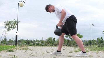 sports and leisure. strong Caucasian man working out using kettlebell in the park video