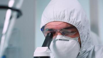 Close up of scientist man in medical industry carrying out genetic analysis using microscope. Chemist researcher in sterile lab doing experiments for medical industry using modern technology video