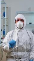 Vertical . Lab technician in ppe suit working with virtual reality in chemical laboratory. Team of biologists examining vaccine evolution with high tech and technology researching treatment against covid19 virus video