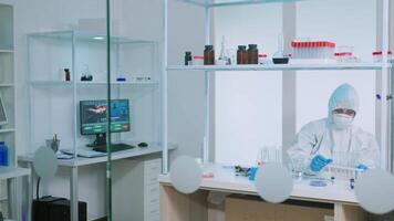 Team of scientists in ppe suit working in lab analysing test trial vaccine checking drug data. Doctors examining virus evolution using high tech for research of treatment development against covid19 video