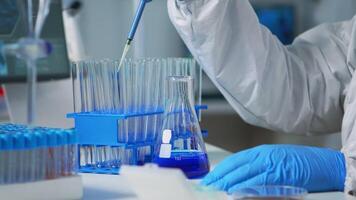 Close up of researcher testing liquid sample using micropipette for new treatment medical laboratory. Team of doctors examining virus evolution using high tech for vaccine development against covid19 video