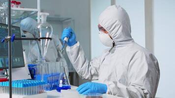 Laboratory scientist working in modern lab with test tubes and micropipette. Team of chemists examining virus evolution using high tech for scientific research of treatment development against covid19 video