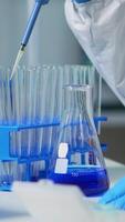Vertical . Close up of researcher testing liquid sample using micropipette for new treatment medical laboratory. Team of doctors examining virus evolution using high tech for vaccine development against covid19 video