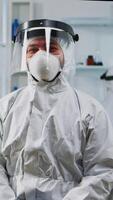 Vertical . Portrait of experienced scientist man in coverall smiling at camera wearing protection mask in equipped lab. Examining virus evolution using high tech and chemistry tools for vaccine development. video