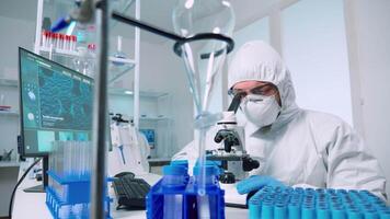 Man research scientist in coverall looking at samples under microscope in modern equipped laboratory. Doctor working with various bacteria, tissue, blood tests, pharmaceutical research for antibiotics video