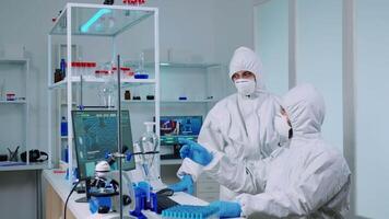 Biotechnology scientist wearing ppe suit researching in equipped laboratory. Team of chemists examining virus evolution using high tech for scientific research of vaccine development against covid19 video
