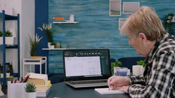 Middle aged woman engineer working with architectural plans, cad software on laptop computer. Designer using digital arhitecture blueprints of buildings working overtime, creating and studying video