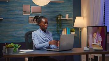 Tired exhausted african freelancer closing laptop and leaving the room late at night taking break. Focused employee using modern technology network wireless doing overtime reading writing, searching video