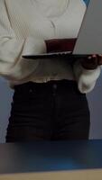 Happy african freelancer looking at camera smiling holding laptop standing near desk in start-up company late at night. Focused employee doing overtime for job respecting deadline of financial project video