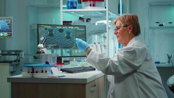 Medical research scientist typing codes on pc in biological applied science modern equipped laboratory overwork. Lab engineers conducting experiment for vaccine development against covid19 virus video