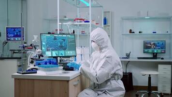 Doctor with protection suit working with blood samples in laboratory typing on computer. Chemist examining vaccine evolution using high tech for research in treatment development against covid19 virus video