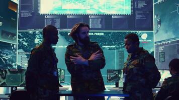 Army officers review data on a hologram to create a brief for the new mission, thinking of an operational plans after gathering important field information. High tech holographic image. Camera B. video