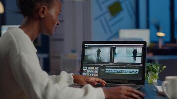 African videographer working at laptop from business office, editing and audio footage at night. Content creator using professional device modern technology network wireless processing film montage. video