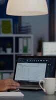 African architect analysing digital plans from laptop working in start-up business office overtime. Designer using cad software to design a 3D concept of buildings creating late at night video