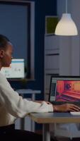 Dark skin gamer developer working at game in midnight from business office using professional laptop. African player testing online games on pc with modern technology network wireless. video