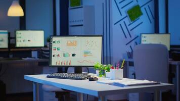 Empty start up business office with modern design during night with graphics running on the desktop. Financial company with nobody in it, place of work startup, workplace indoors concept video