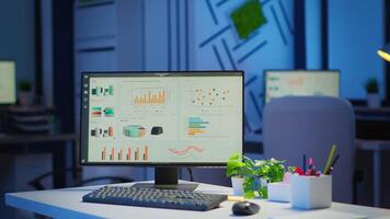 interior de vacío comienzo arriba negocio oficina con moderno diseño durante noche con gráficos corriendo en el escritorio. financiero empresa con nadie en él, sitio de trabajo puesta en marcha, lugar de trabajo adentro concepto video