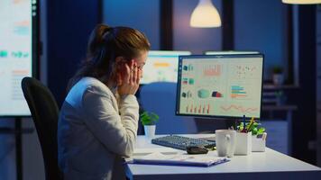 Exhausted manager trying to finish business project respecting deadline working at night in front of computer taking notes writing on notebook. Tired employee overtime sitting at desk in workplace video