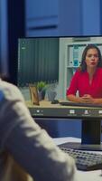 Vertical . Manager woman talking with coworker during conference at midnight from business office planning financial strategy. Lady using modern technology network wireless discussing at virtual meeting video
