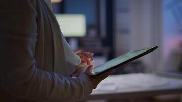 Close up of woman employee texting, sending and reading messages during break standing in business office late at night. Businesswoman using modern technology network wireless overworking in midnight video