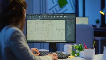 Over the shoulder shot of engineer working with architectural plans, cad software on desktop computer. Designer using arhitecture blueprints of buildings working overtime, creating and studying video