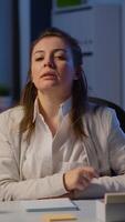 Vertical . Pov of businesswoman having a conference with team during midnight looking in camera in workplace. Lady using modern technology network wireless talking on virtual meeting at doing overtime video