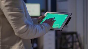 Close-up photo of woman hands holding tablet computer analysing graphs standing in start-up office late at night. Business woman using social network, texting and blogging working overtime for job video