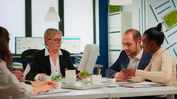 Young businessman reading documents, sign its and consultant greeting international client with handshake after planning partnership deal. Executive director meeting shareholders in start up office video