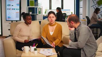 Angry manager woman arguing disagreeing about bad business contract, diverse colleagues having conflict dispute about document sitting on couch at office desk, partners shouting breaking agreement. video