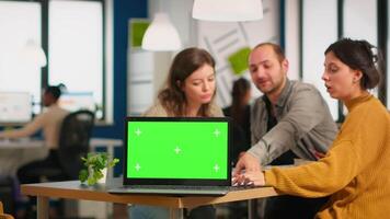 grupp av företag människor diskuterar företag planen med attrapp bärbar dator i främre av kamera, pc redo för finansiell projekt presentation placerad på skrivbord. ledare använder sig av grön skärm pc med krom nyckel visa video