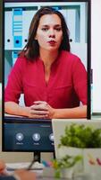 Diverse team of coworkers talking with project manager using web cam during business conference sitting in broadroom. Employees interacting with manager on virtual meeteing, online briefing. video