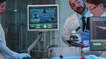 Group of researchers checking virus evolution conducting vaccine development with help of high tech, analysing results and planning next steps working late at night in modern equipped laboratory video