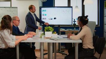 Succesful business man presenting the good evolution of company using digital interactive whiteboard with growth analysis, charts, statistics, data, Diverse people congratulate him clapping video