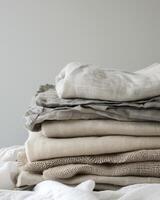 Pile of linen fabrics, neatly folded stack of linen in various shades of beige, fabrics textiles, neutral colours photo