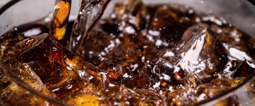 Cola soda and ice splashing fizzing or floating up to top of surface photo