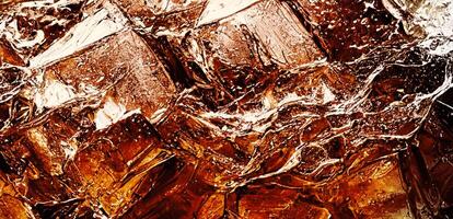 Cola with Ice. Close up of the ice cubes in cola water. Texture of carbonate drink with bubbles in glass. Cola soda and ice splashing fizzing or floating up to top of surface. Cold drink background. photo