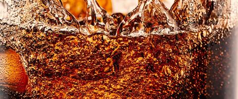 Splashing of Cola and Ice. Cola soda and ice splashing fizzing or floating up to top of surface. Close up of ice in cola water. Texture of carbonate drink with bubbles in glass. Cold drink background photo