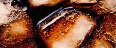Cola with Ice. Close up of the ice cubes in cola water. Texture of carbonate drink with bubbles in glass. Cola soda and ice splashing fizzing or floating up to top of surface. Cold drink background. photo