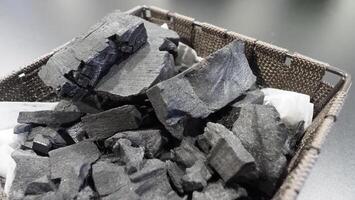Natural wood charcoal traditional charcoal or hard wood charcoal on wooden table top view. photo