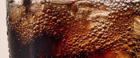 Cola soda and ice splashing fizzing or floating up to top of surface photo