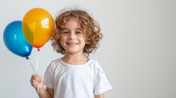 Smiling child holding a colorful balloon, standing on a white background with ample copy space, perfect for birthday and celebration themes photo
