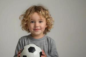 Happy child playing with a soccer ball, standing on a simple white background with plenty of empty space, great for sports and activity themes photo