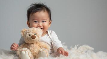 Smiling baby sitting with a teddy bear, on a simple studio backdrop with plenty of blank space, perfect for baby product advertisements and cute themes photo