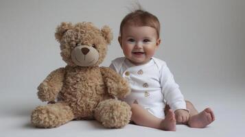 Smiling baby sitting with a teddy bear, on a simple studio backdrop with plenty of blank space, perfect for baby product advertisements and cute themes photo