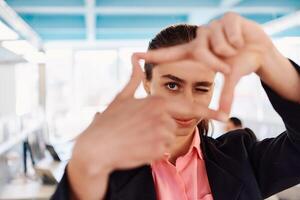 Closeup of hands, Smiling Business Woman Making Frame Gesture with at modern bright coworking open space startup office photo