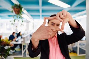Closeup of hands, Smiling Business Woman Making Frame Gesture with at modern bright coworking open space startup office photo