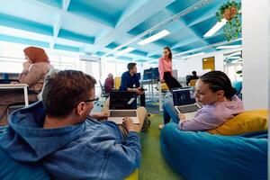 In a modern startup office, a diverse group of young and capable businesspeople engage in lively discussions about various projects, showcasing teamwork, innovation, and entrepreneurial spirit photo