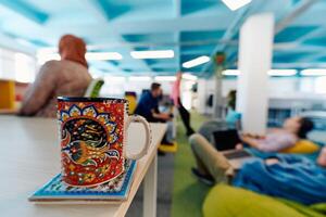 In a modern startup office, a diverse group of young and capable businesspeople engage in lively discussions about various projects, showcasing teamwork, innovation, and entrepreneurial spirit photo