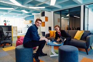 Multiethnic startup business team on meeting in a modern bright open space coworking office. Brainstorming, working on laptop. Group of coworkers walking around in motion blur photo