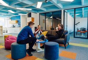 Multiethnic startup business team on meeting in a modern bright open space coworking office. Brainstorming, working on laptop. Group of coworkers walking around in motion blur photo